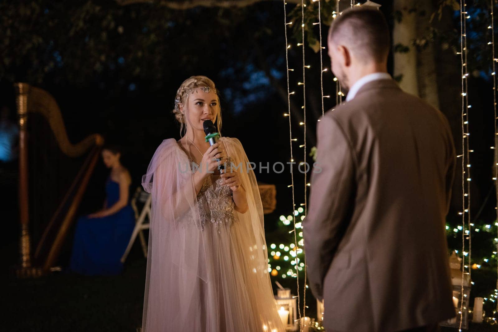 night wedding ceremony of the newlyweds in a country cottage on a green hill