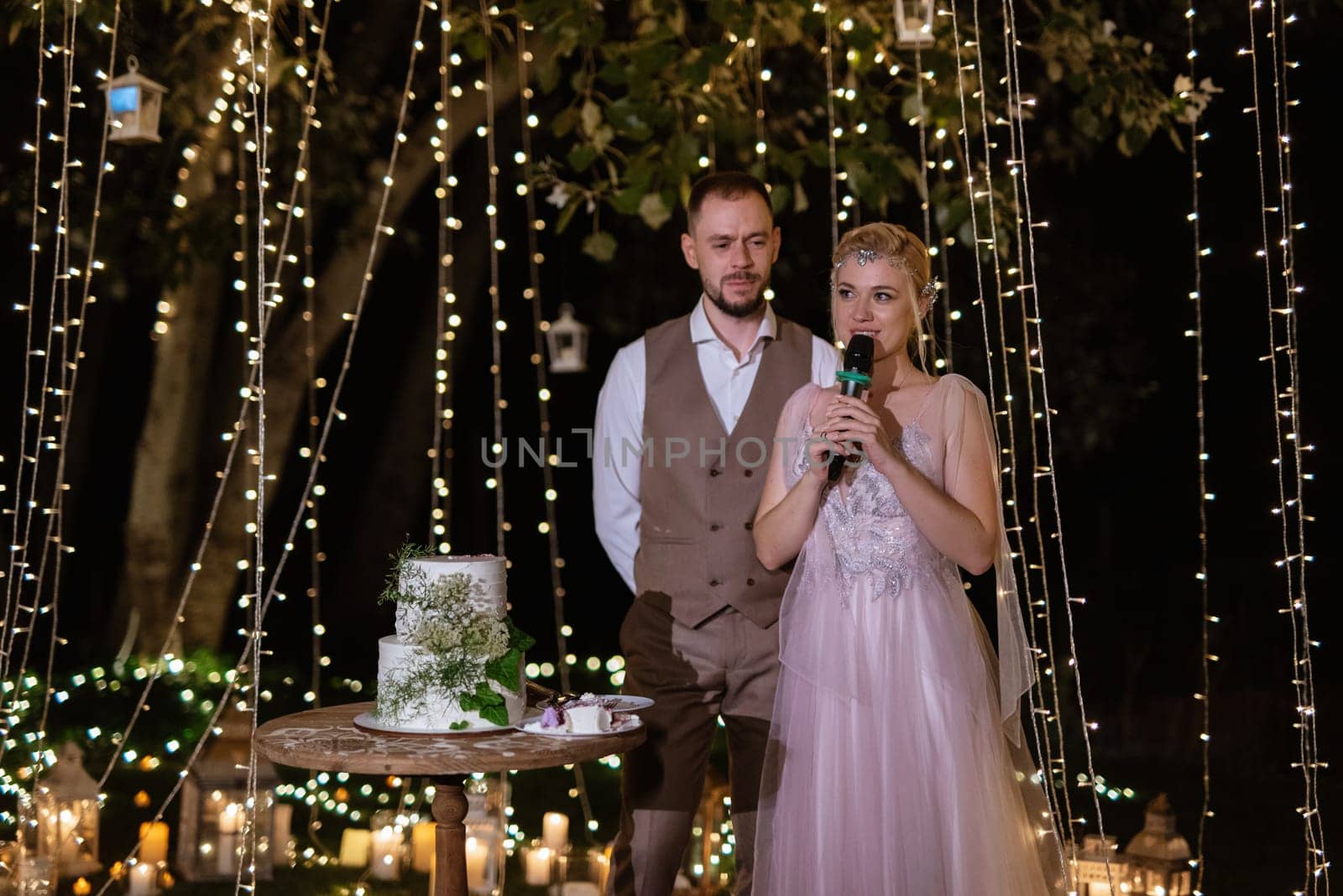 newlyweds happily cut and taste the wedding cake by Andreua