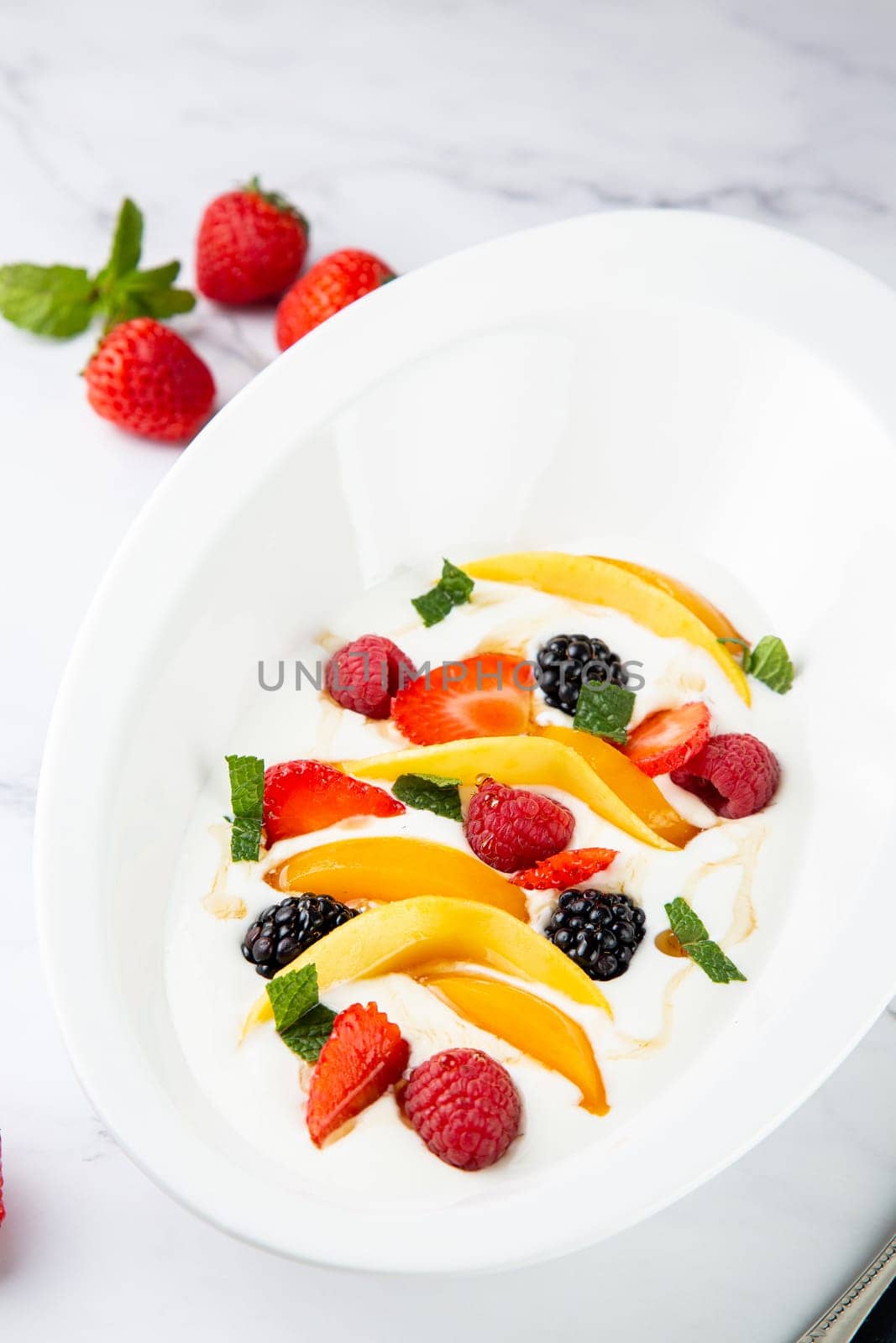 fruit salad with wild berries and strawberries side view by tewolf