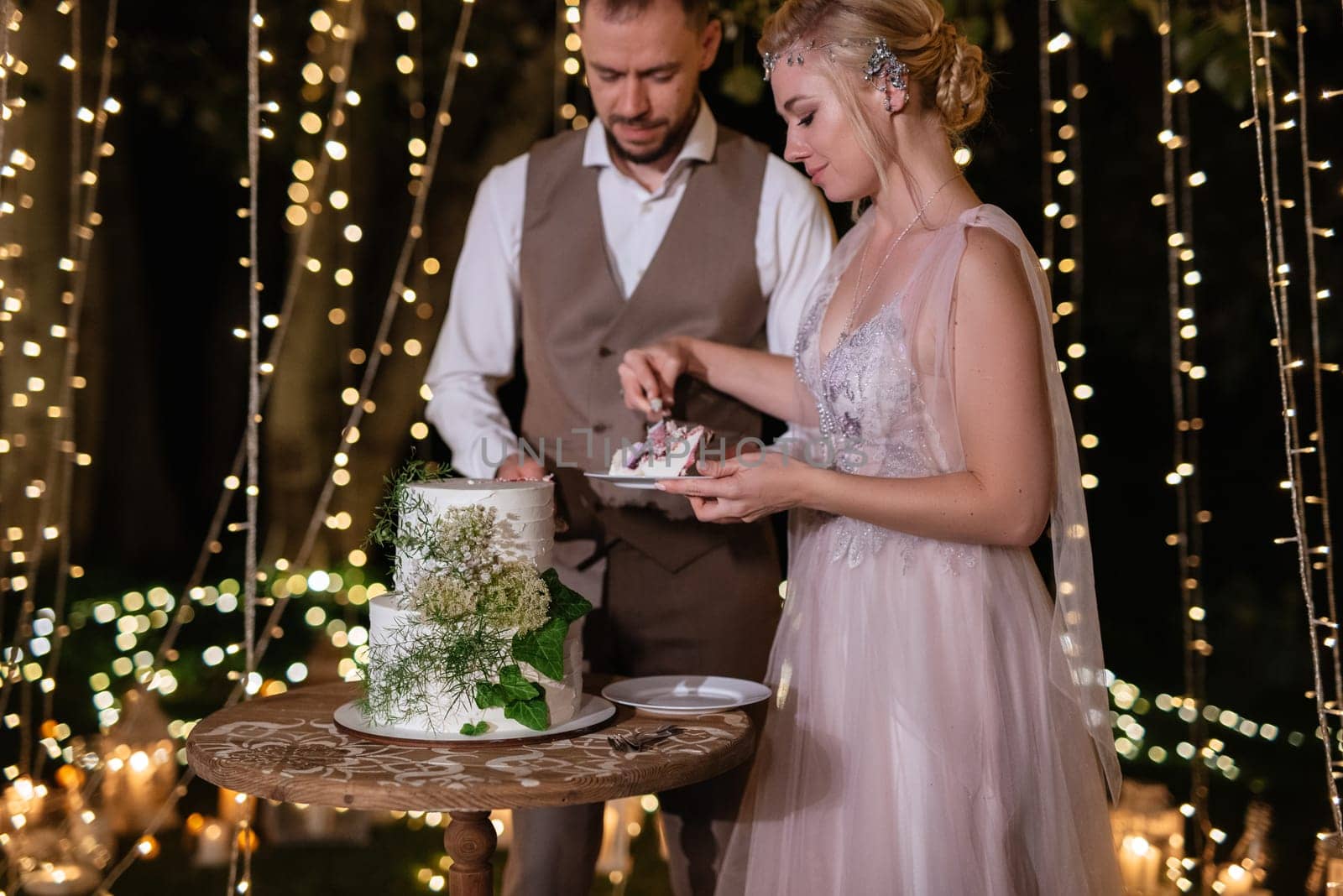 newlyweds happily cut, laugh and taste the wedding cake