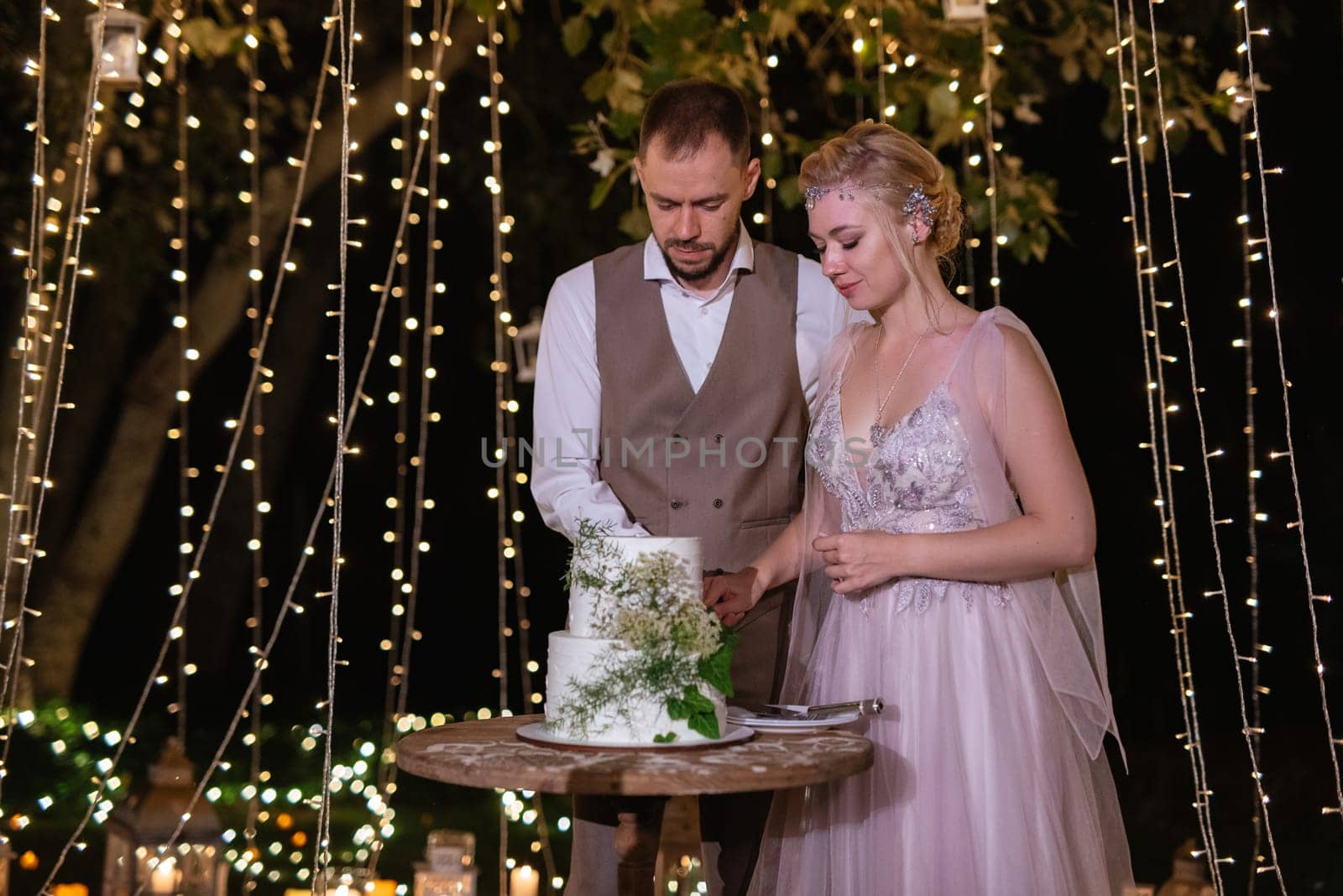 newlyweds happily cut, laugh and taste the wedding cake