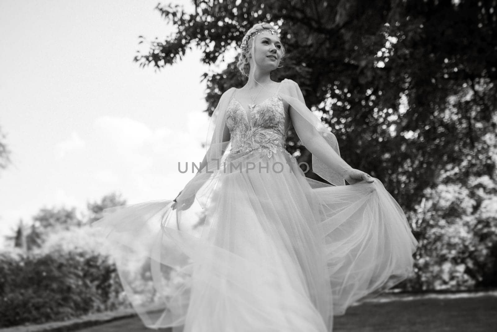 portrait of a happy bride in a light light dress on a green meadow in the park wearing elven accessories