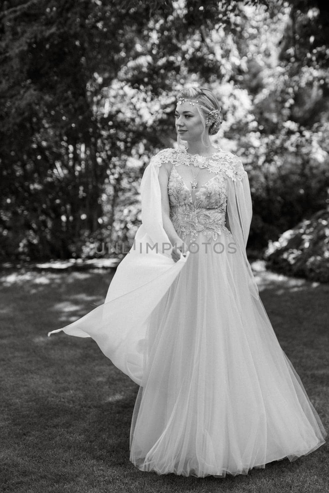 portrait of a happy bride in a light light dress on a green meadow in the park wearing elven accessories