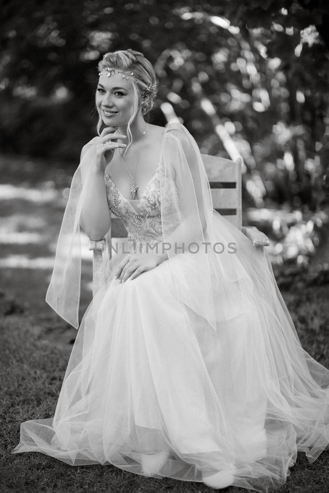 portrait of a happy bride in a light light dress on a green meadow in the park wearing elven accessories