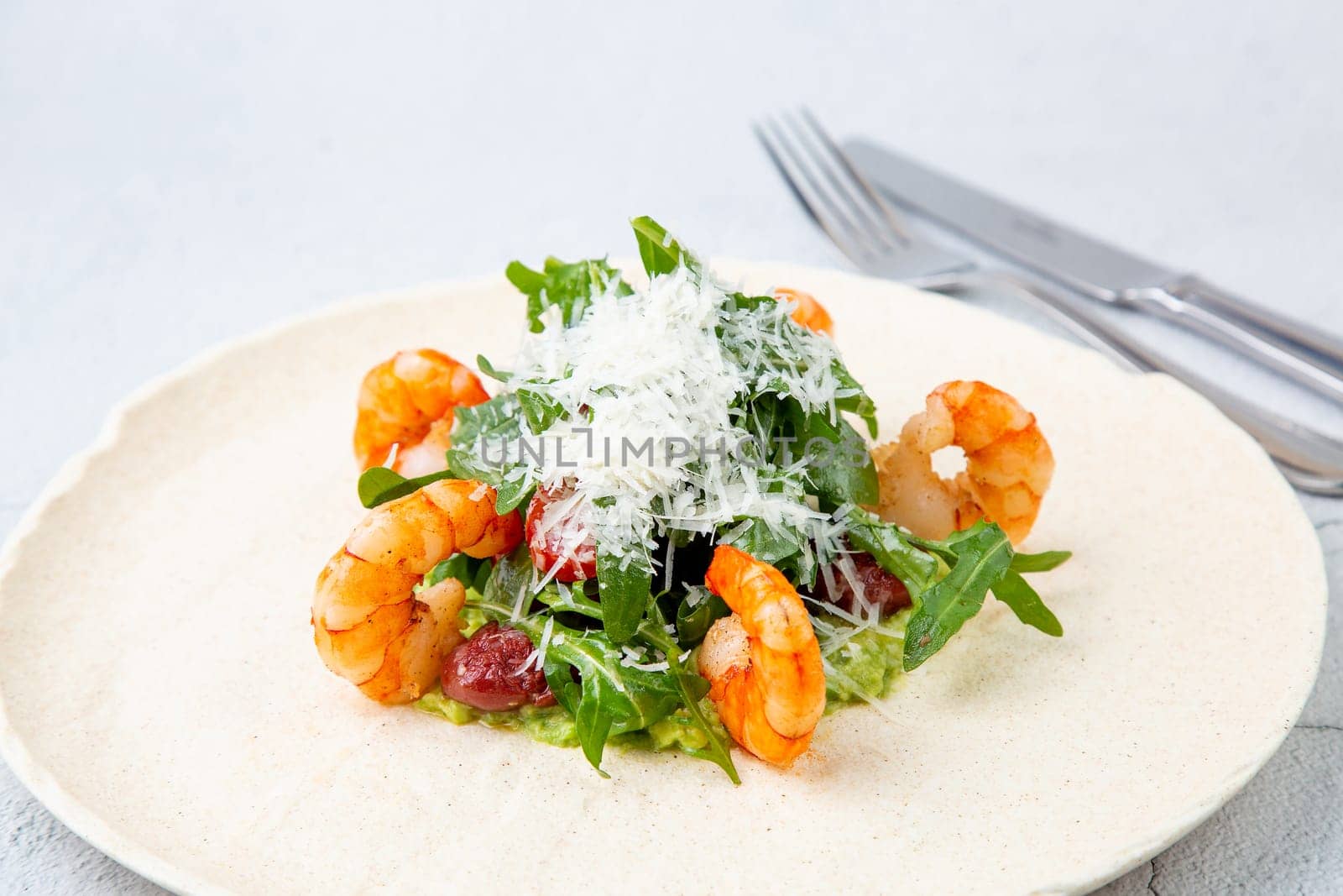 beautifully served shrimp with arugula and grated cheese