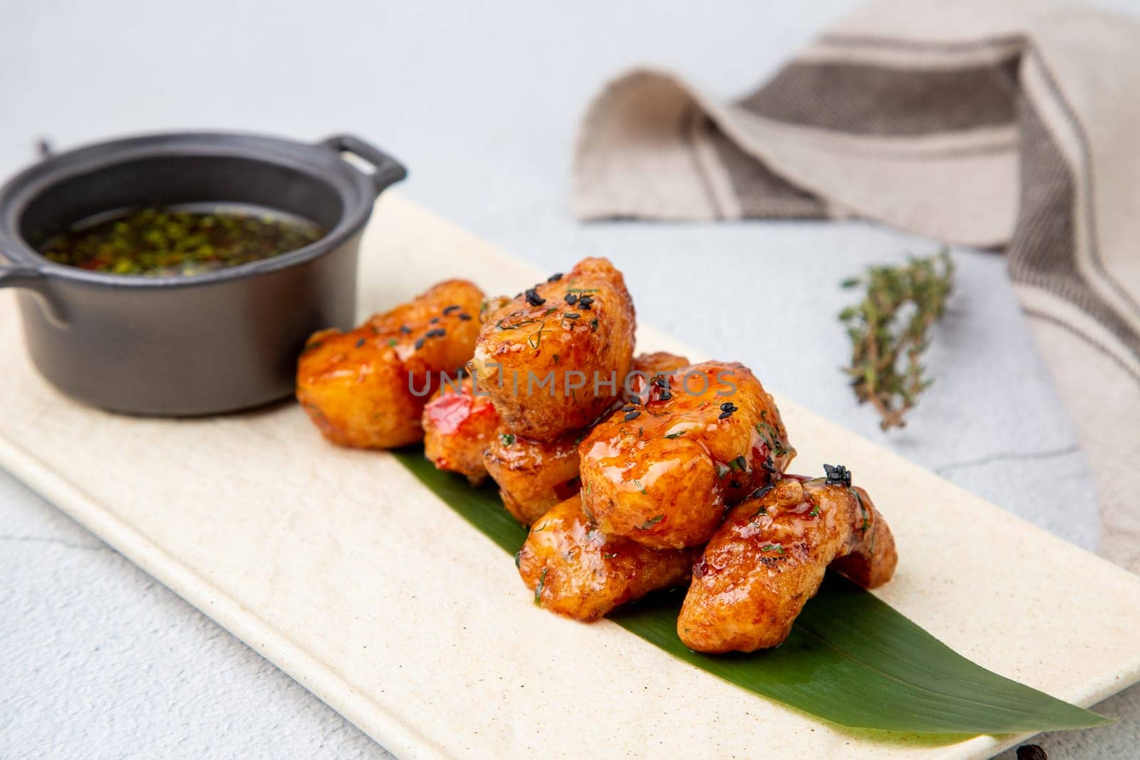 Slices of pike perch in sweet and sour sauce on a banana leaf side view by tewolf