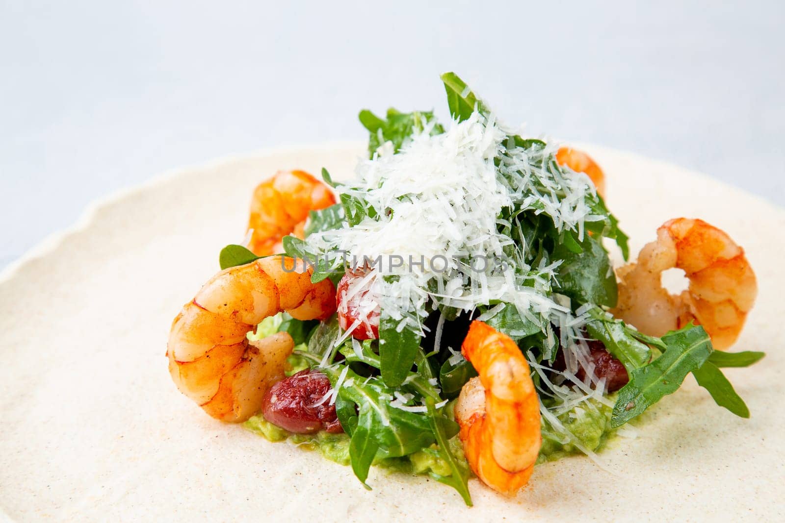 beautifully served shrimp with arugula and grated cheese