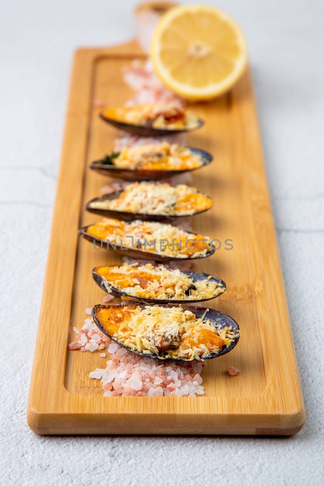 oysters scallops with red sea salt and citric acid on a wooden tray side view by tewolf