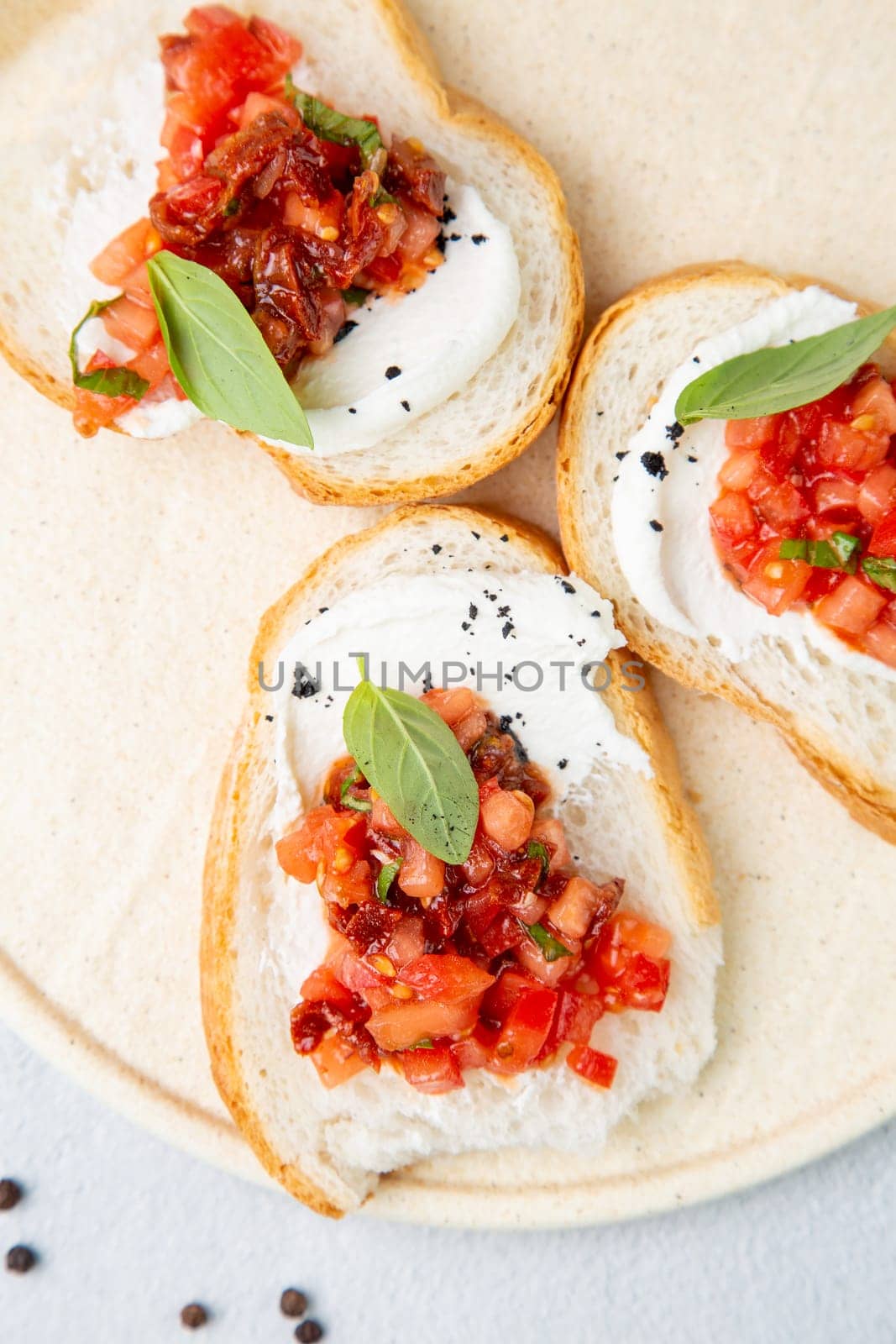 bruschetta with tomatoes and labneh cheese on a light background