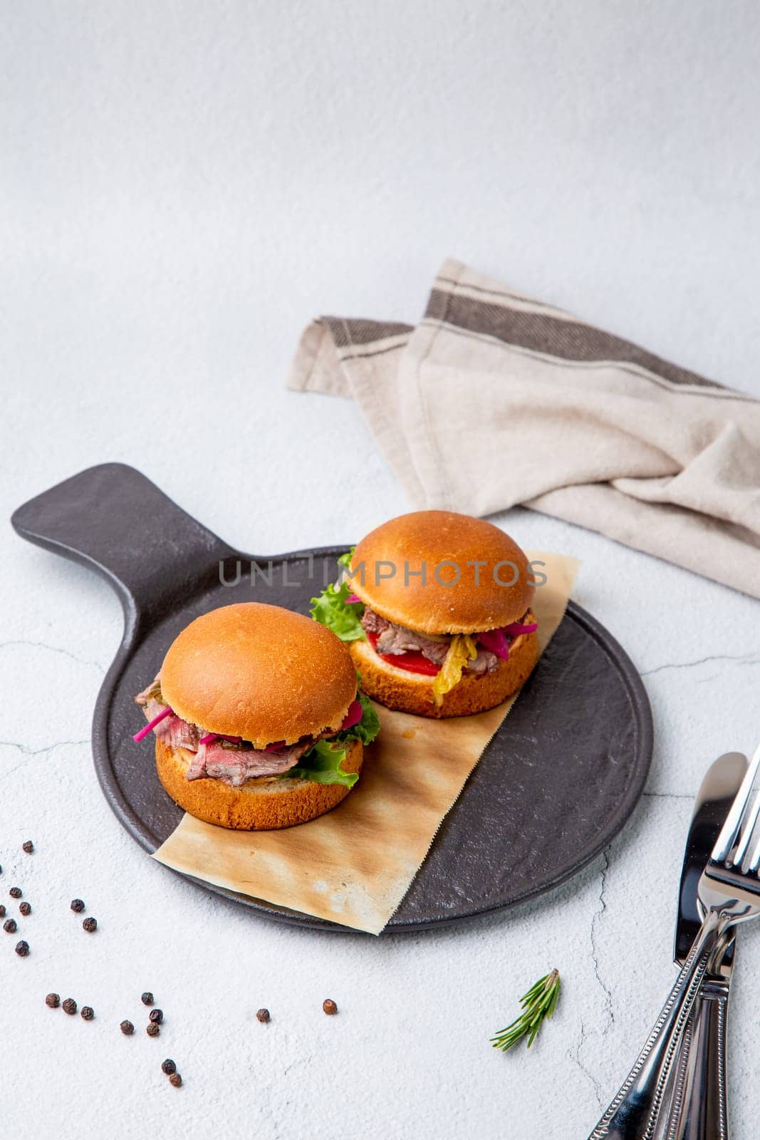 hot burgers with lettuce and vegetables on a wooden board side view by tewolf