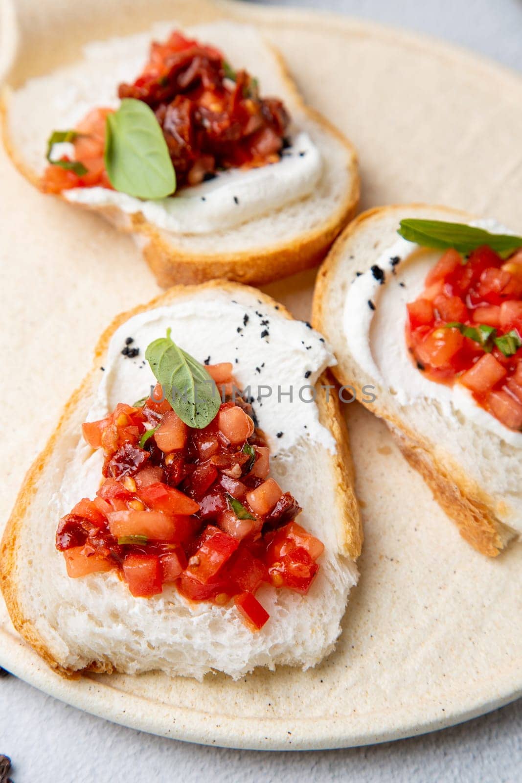 bruschetta with tomatoes and labneh cheese on a light background top view by tewolf