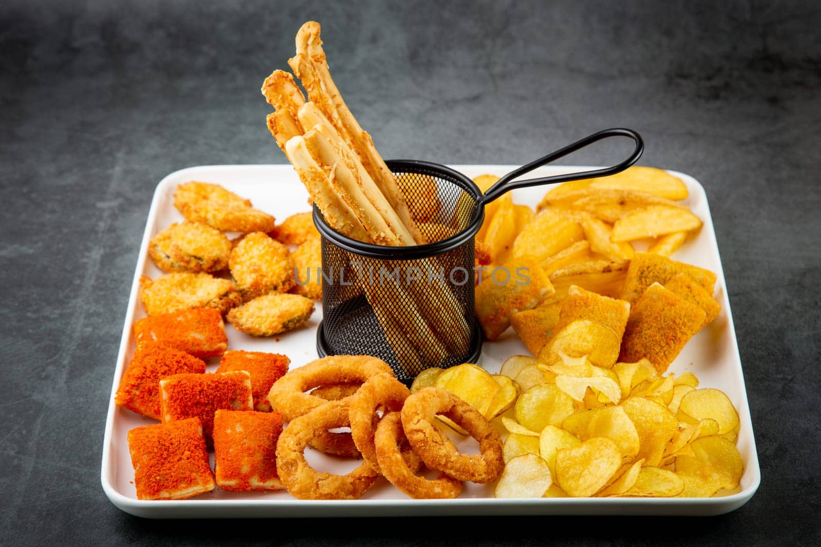 beer set with nuggets, breaded onion rings, fries and sauces side view by tewolf