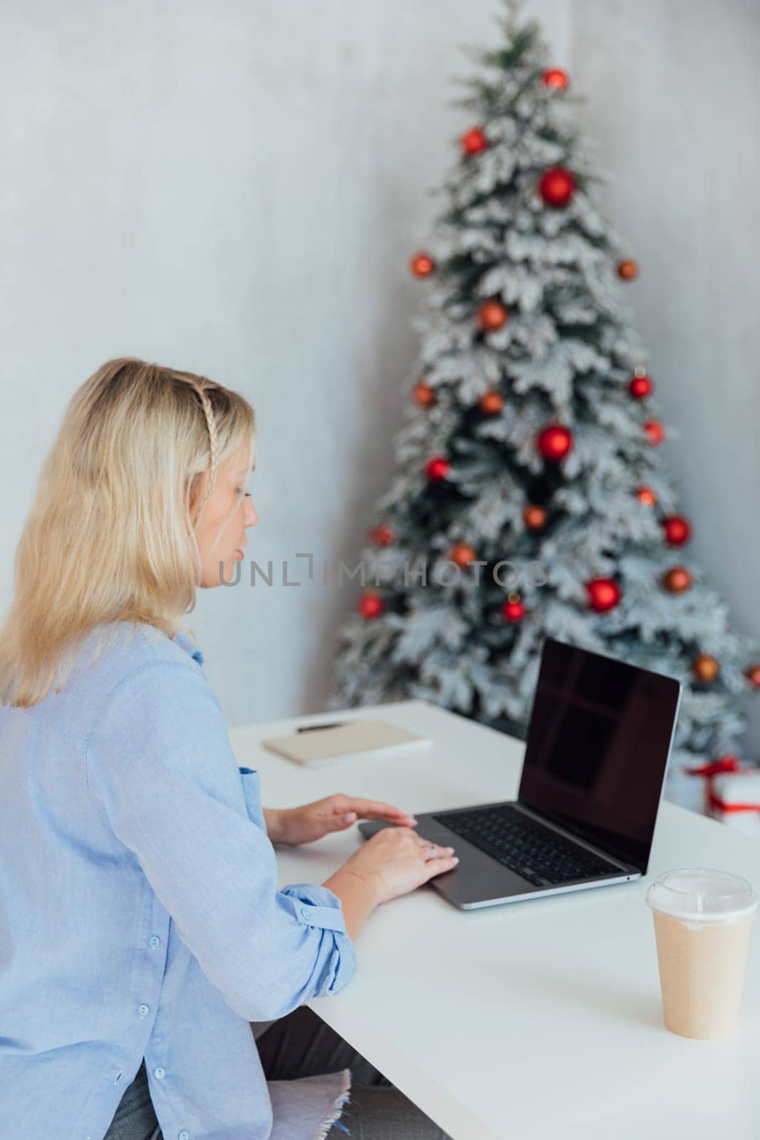 Business woman working behind computer in christmas office by Simakov