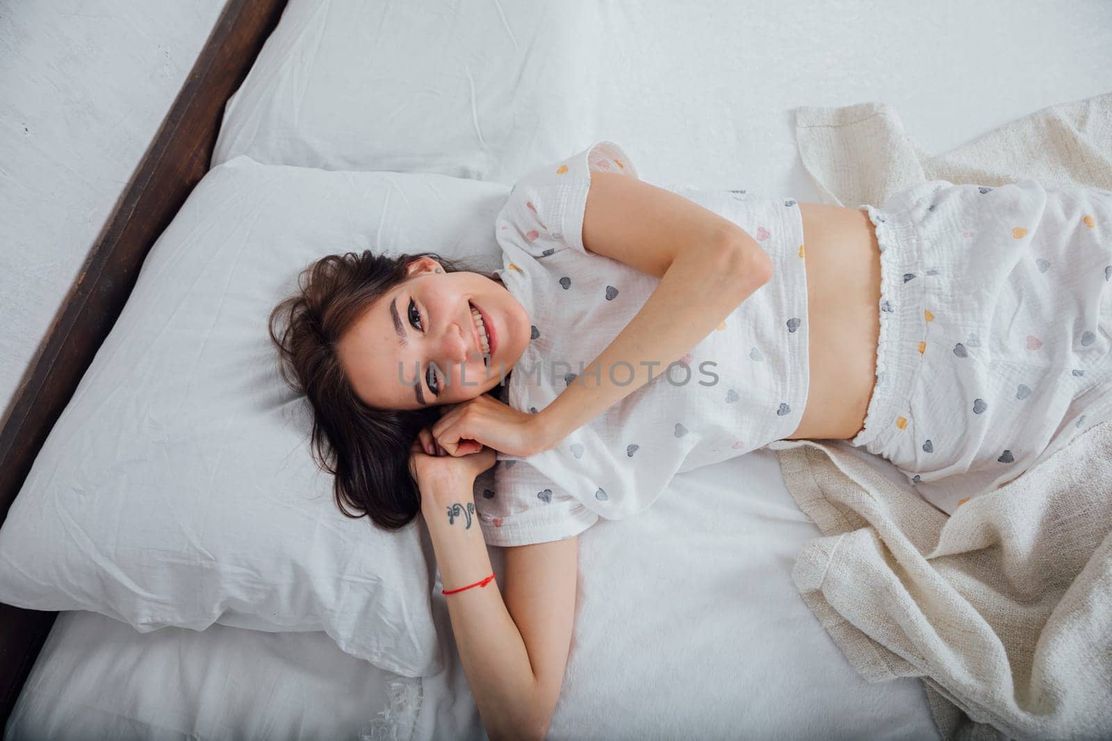 woman in pajamas on bed by christmas tree