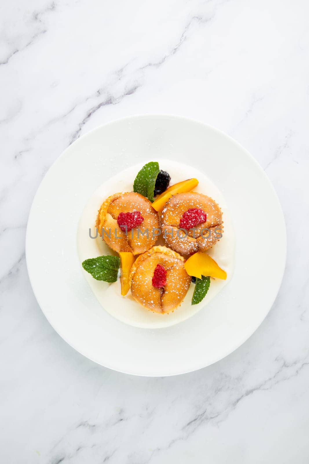 muffins with peach, raspberry, black berry and mint covered with powdered sugar