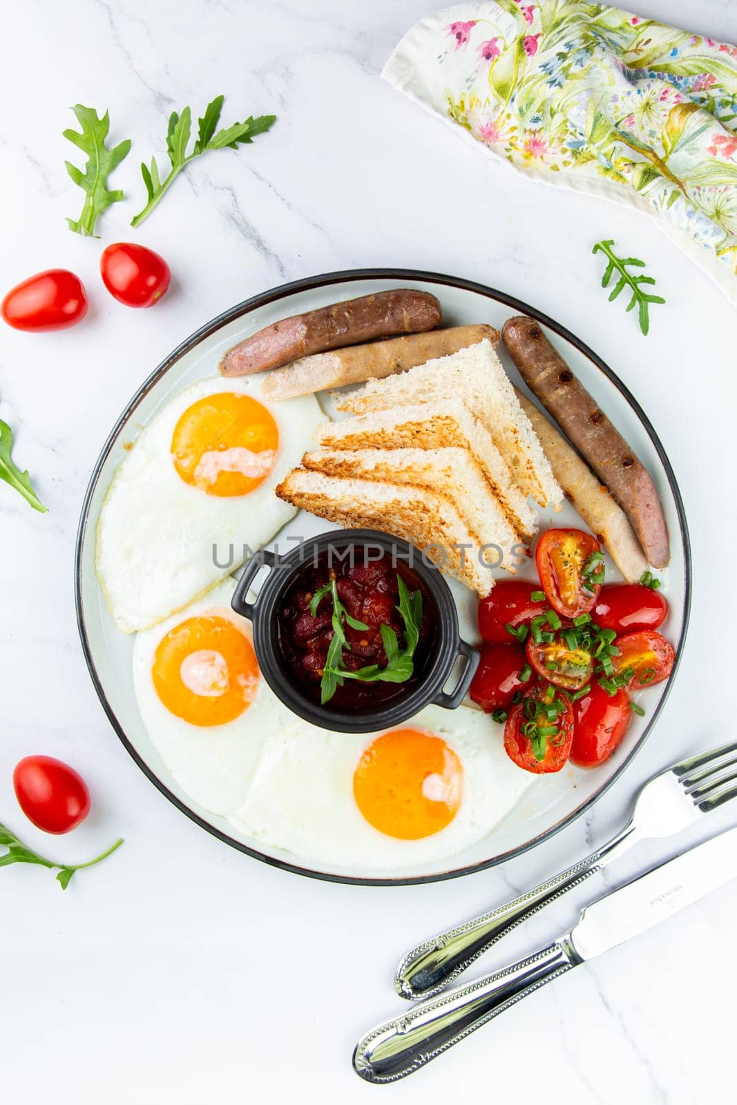 Breakfast of eggs and vegetables with cherry tomatoes and slices of bread top view by tewolf