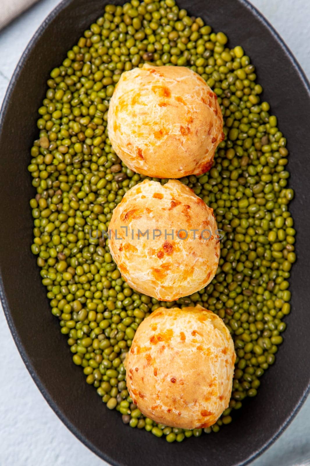 cooked meatballs on peas in an oblong bowl top view by tewolf