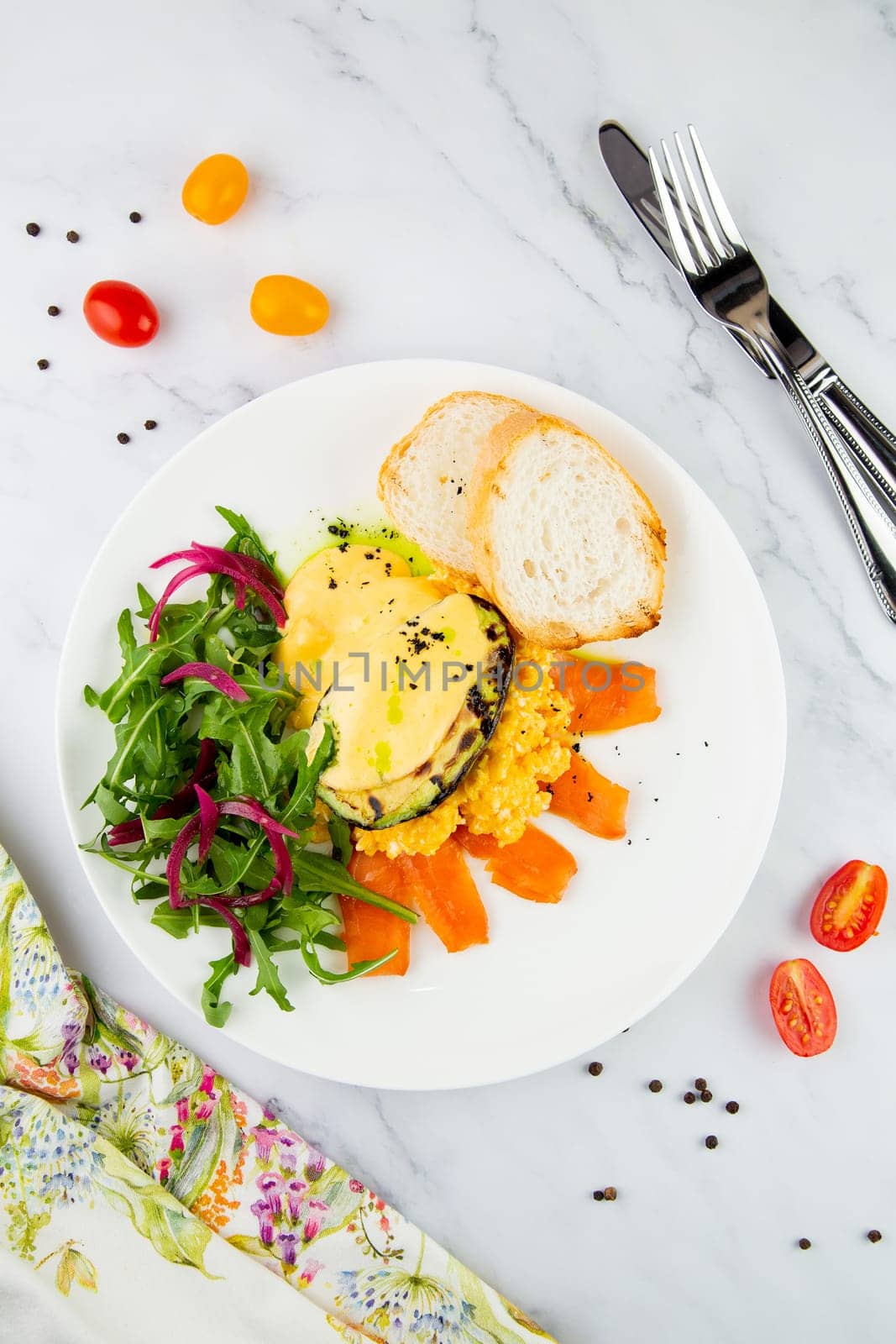 a mix of salmon, arugula salad, white bread and baked avocado with cheese top view by tewolf