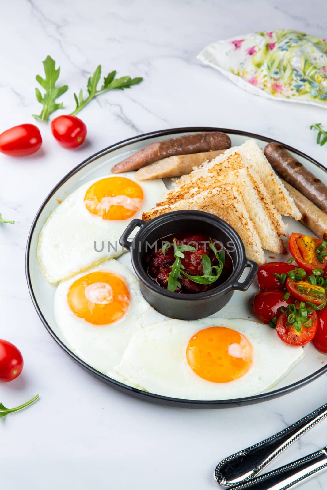 Breakfast of eggs and vegetables with cherry tomatoes and slices of bread