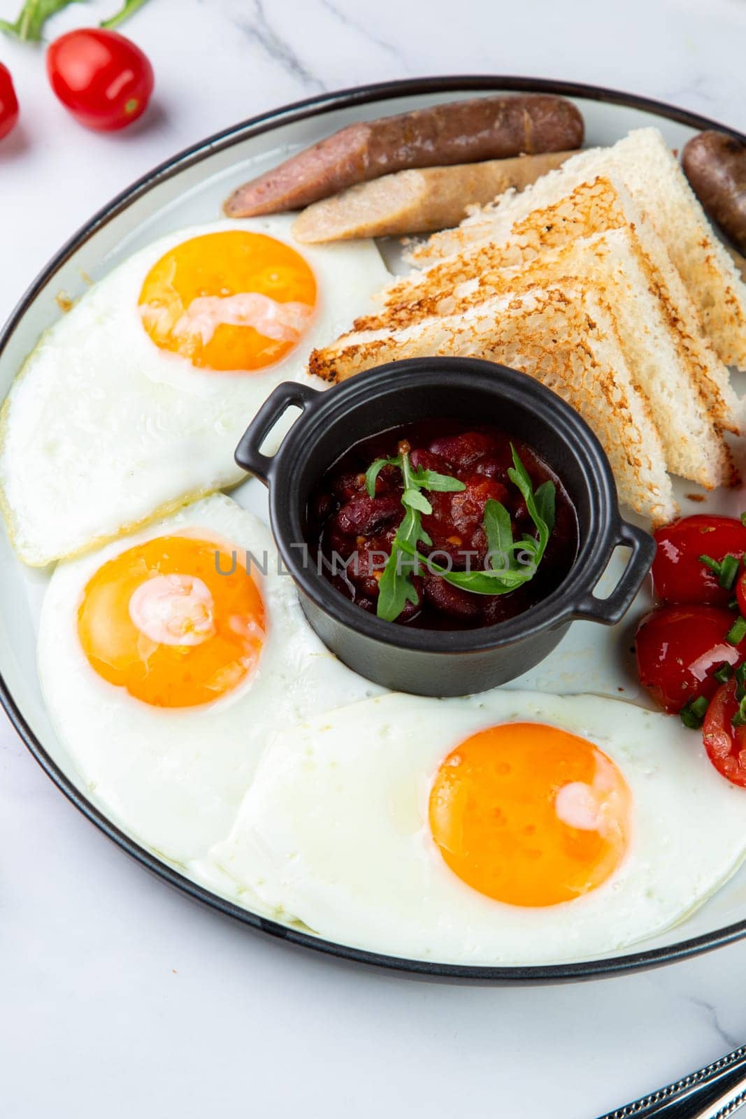 Breakfast of eggs and vegetables with cherry tomatoes and slices of bread