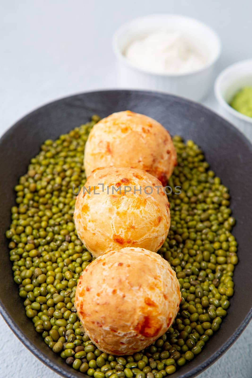 cooked meatballs on peas in an oblong bowl side view by tewolf