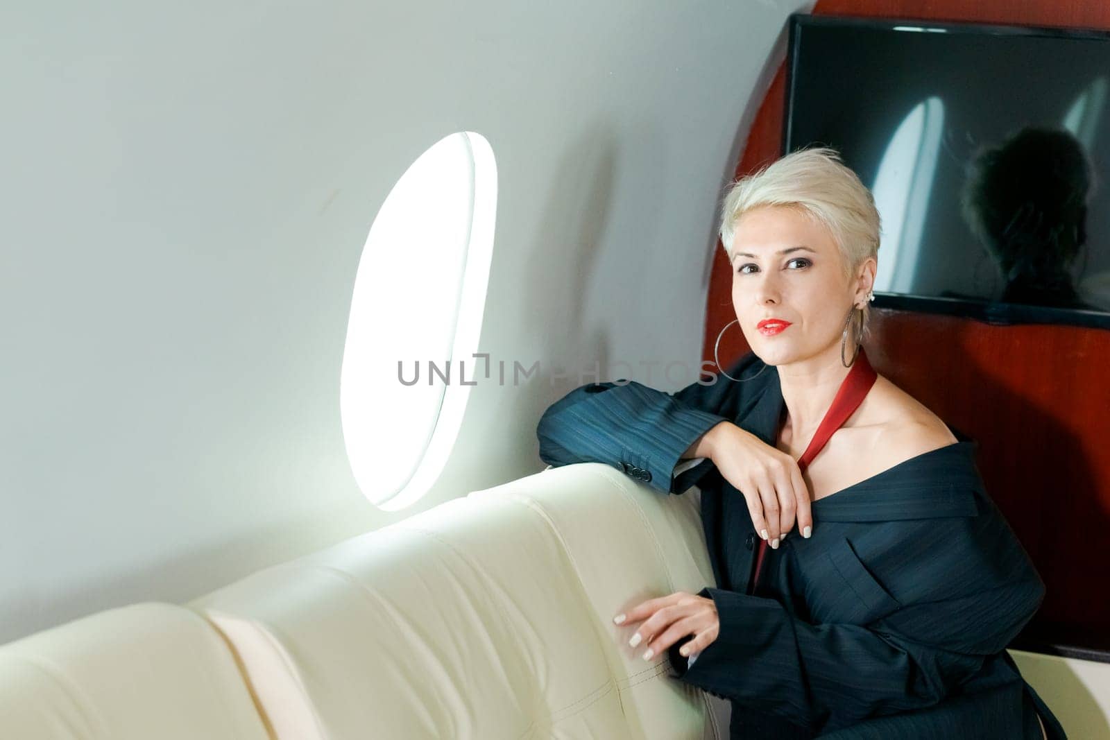 Woman private plane in a jacket with a red tie, New Year's Eve flight, holiday and travel concept