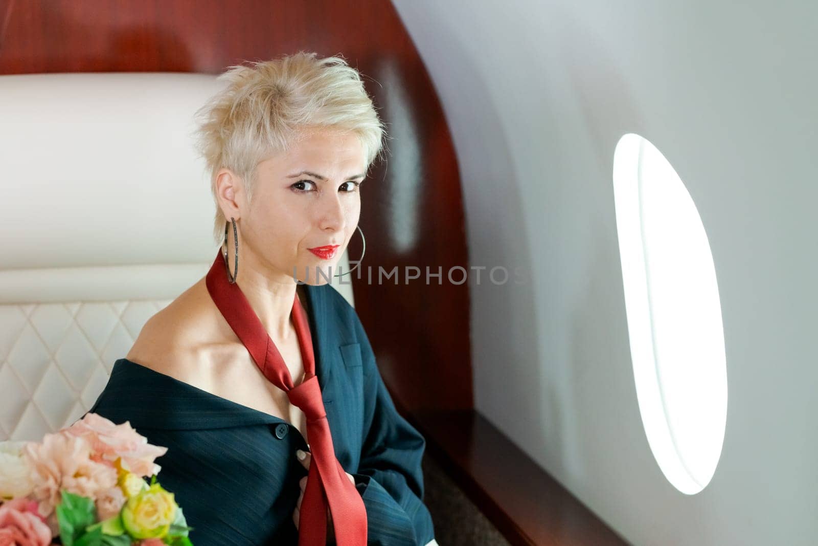 Woman private plane in a jacket with a red tie, New Year's Eve flight, holiday and travel concept