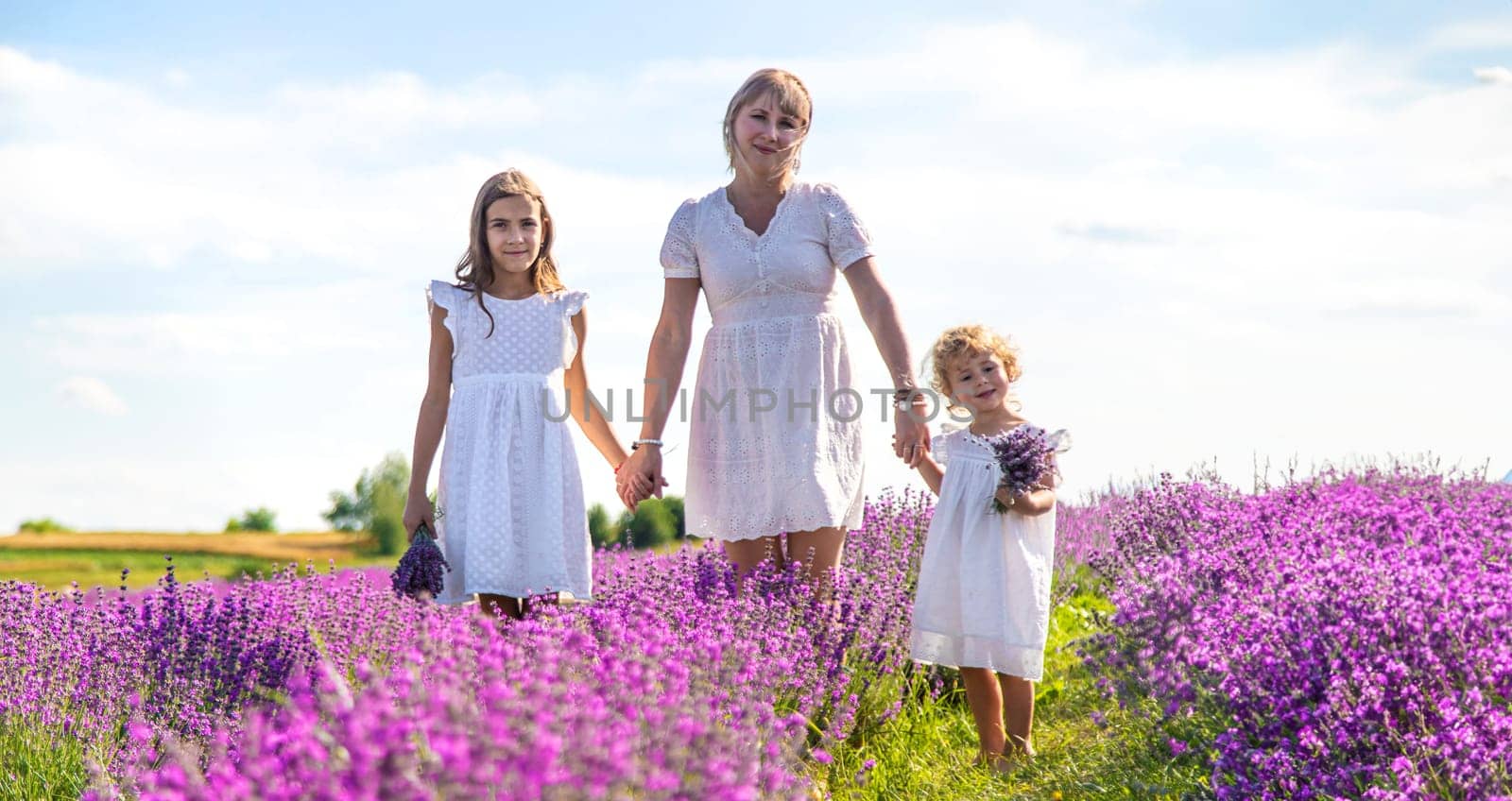 Mother and children in a lavender field. Selective focus. Nature.