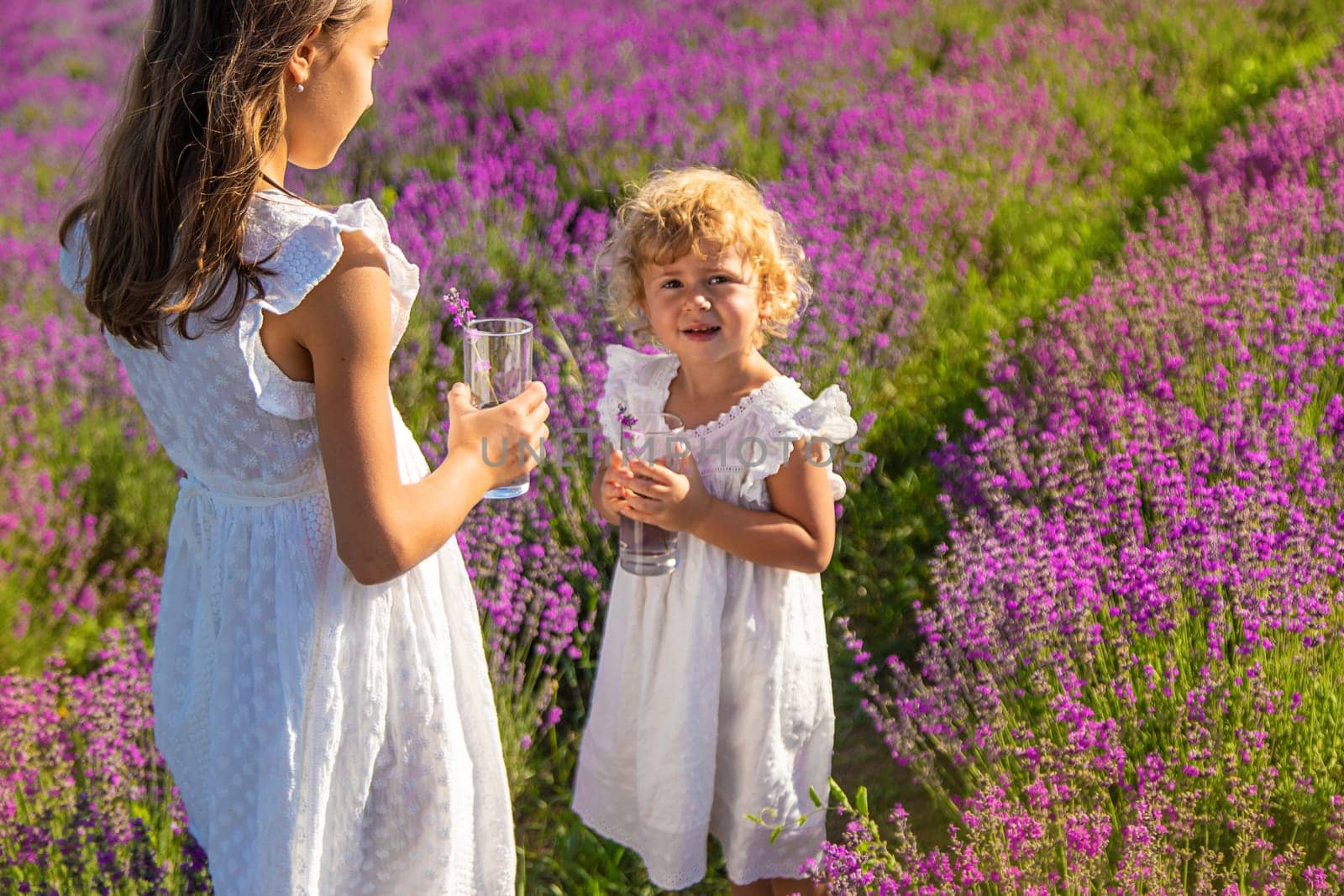 Children in a lavender field drink lemonade. Selective focus. Nature.