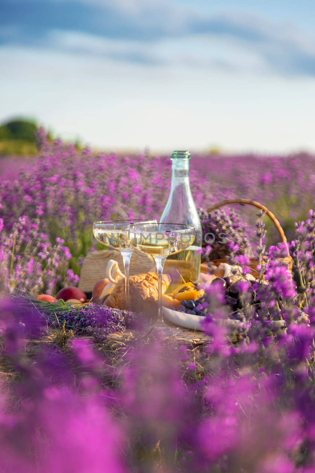 Picnic with wine in a lavender field. Selective focus. by yanadjana