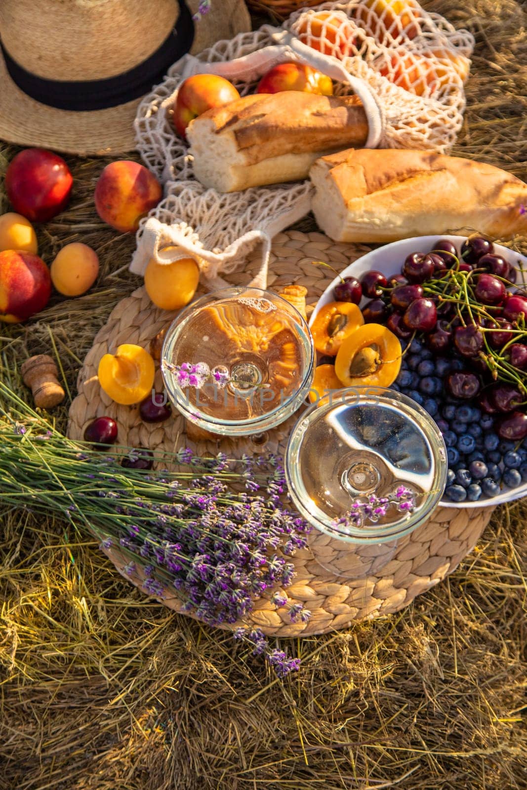 Picnic with wine in a lavender field. Selective focus. by yanadjana