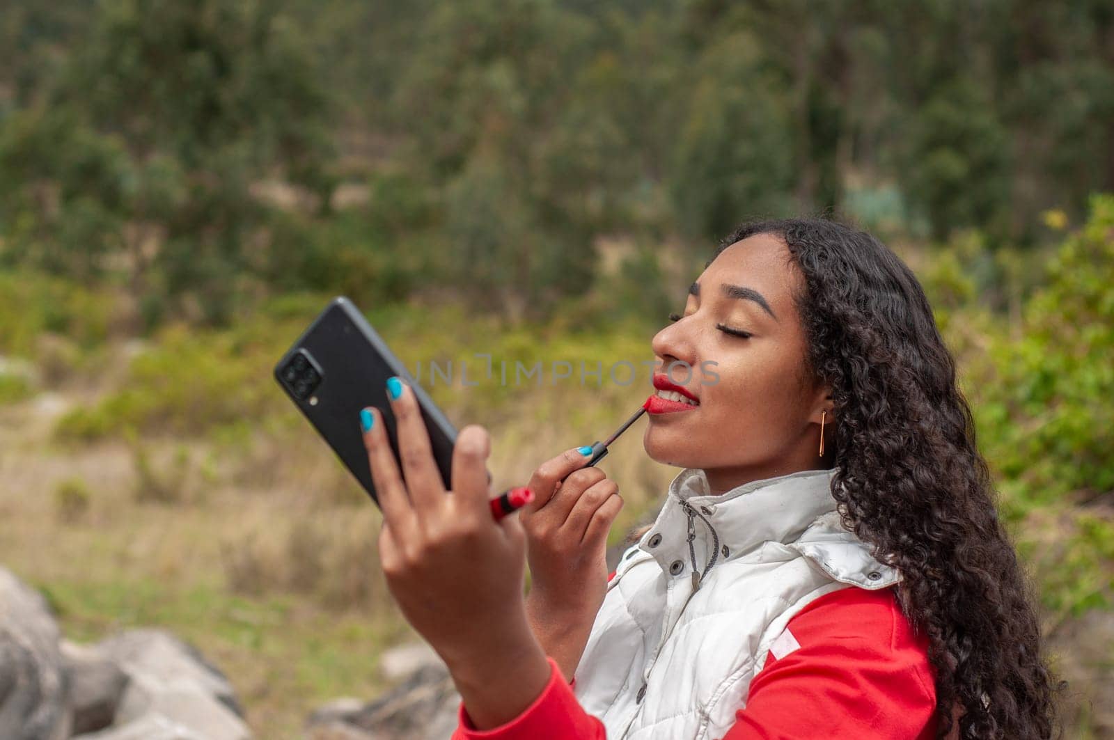 young ecuadorian girl making a makeup tutorial video on a mountain in ecuador. High quality photo