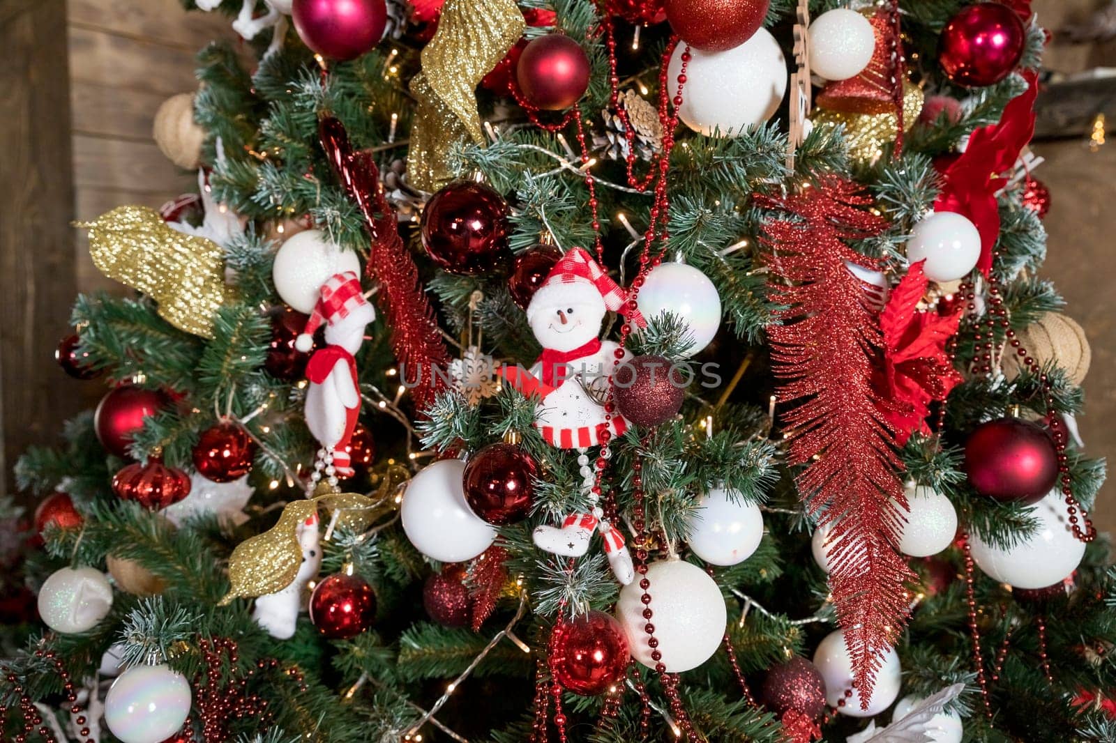 Christmas, New Year interior with red brick wall background, decorated fir tree with garlands and balls, dark drawer and deer figure