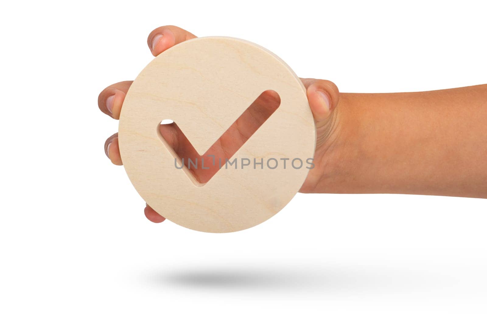 Check mark symbol on white isolated background. Big wooden round badge check stamp in hand close up. High quality photo