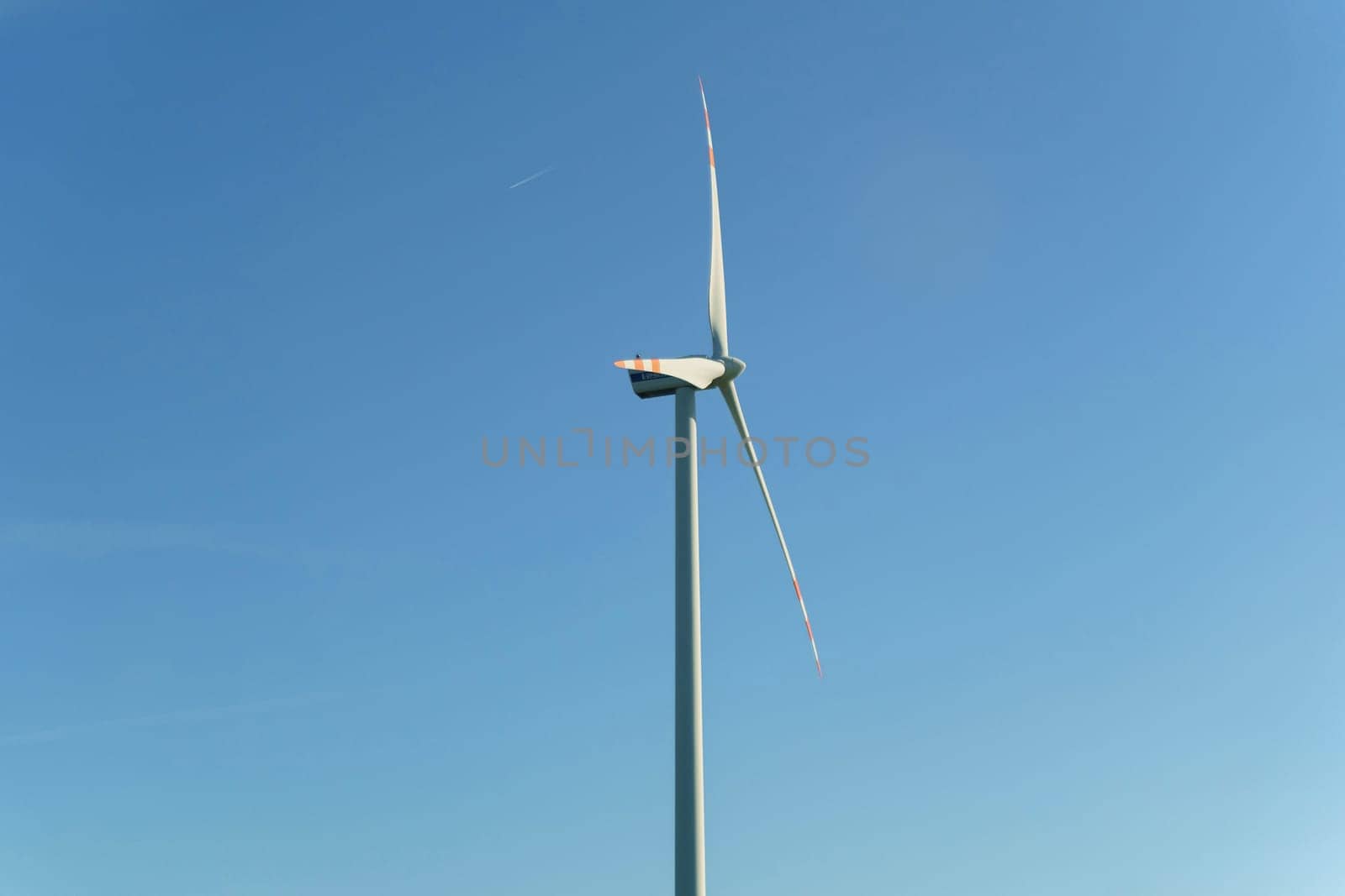 Wind turbine for power generation outdoors with sun and blue sky. Concept of alternative energy sources