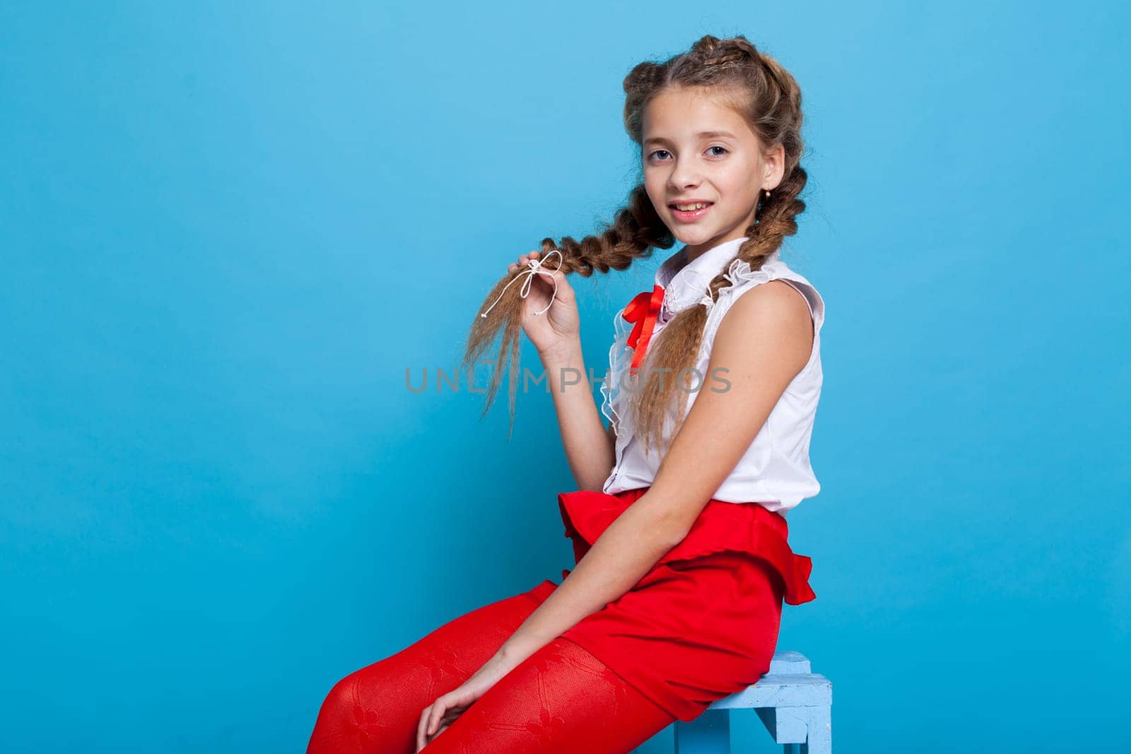 Schoolgirl girl in red white dress on a blue background by Simakov