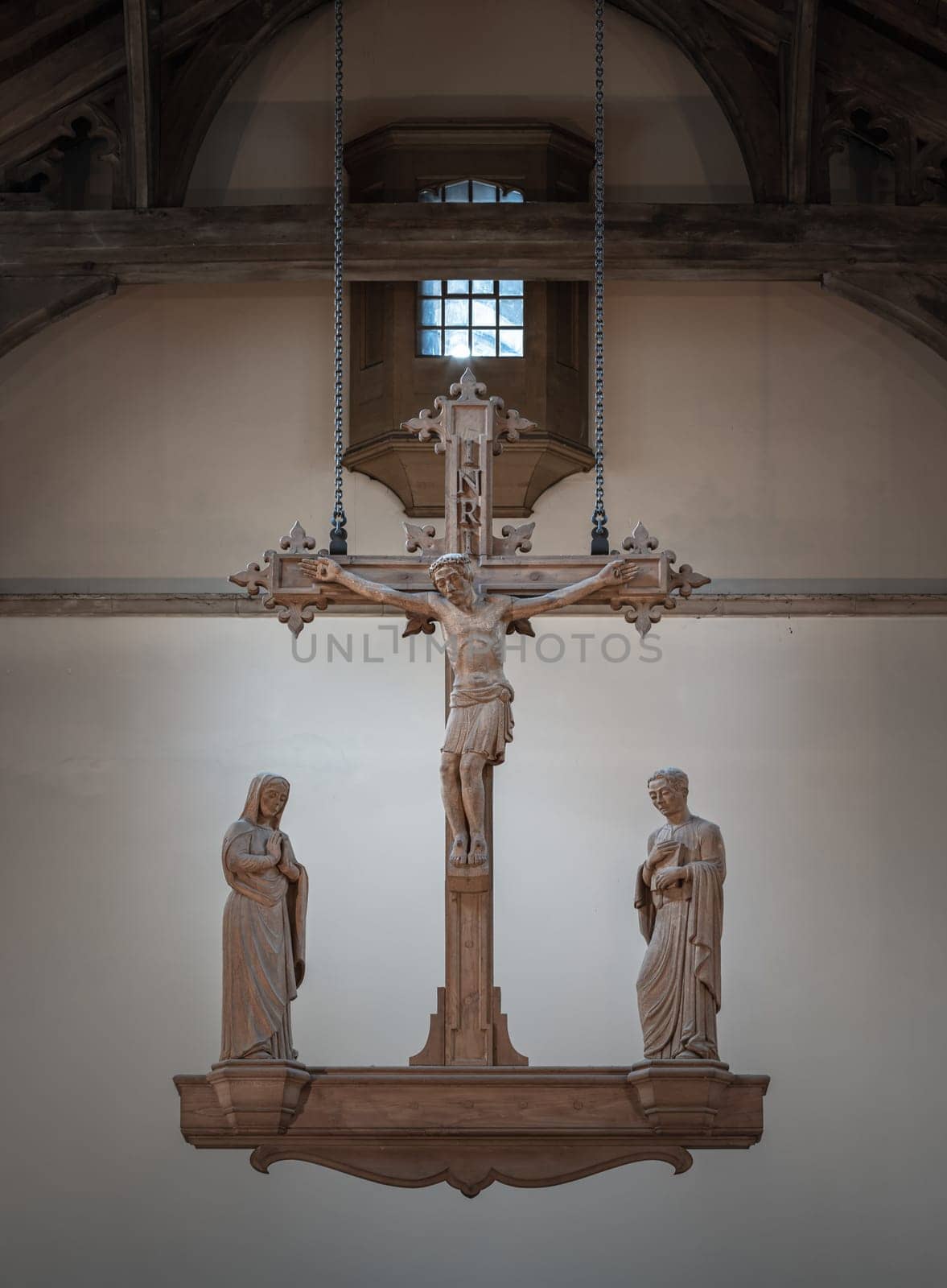 Liverpool, UK - Oct 07, 2023 - The Rood, hanging above the altar. Jesus hanging on the cross and The Virgin Mary and St.John (The evangelist) statues at Our Lady and St Nicholas Church, The figure of Jesus Christ, Space for text, Selective focus.