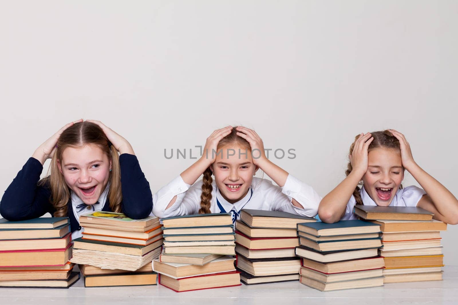 three girls at school with lots of books by Simakov