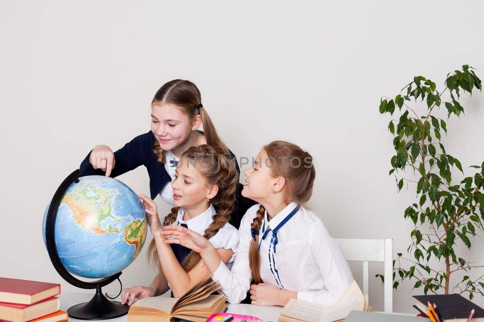 girls watching the globe in geography class