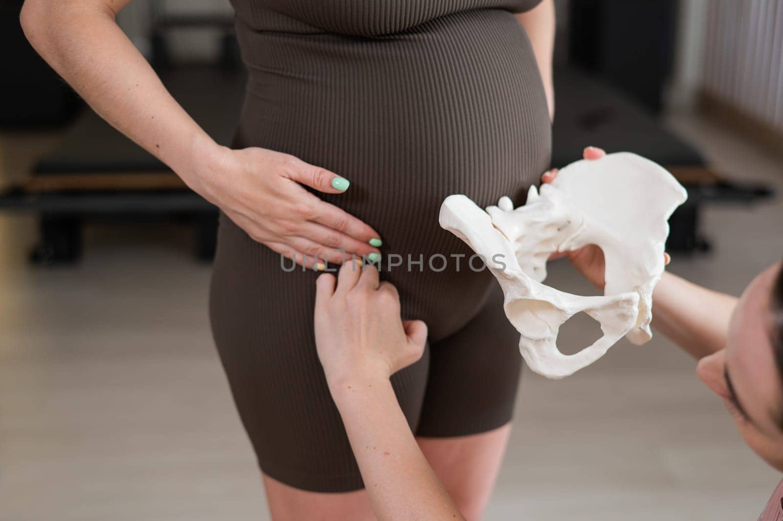 Doula explains the process of childbirth on a sample of the pelvis of a pregnant woman