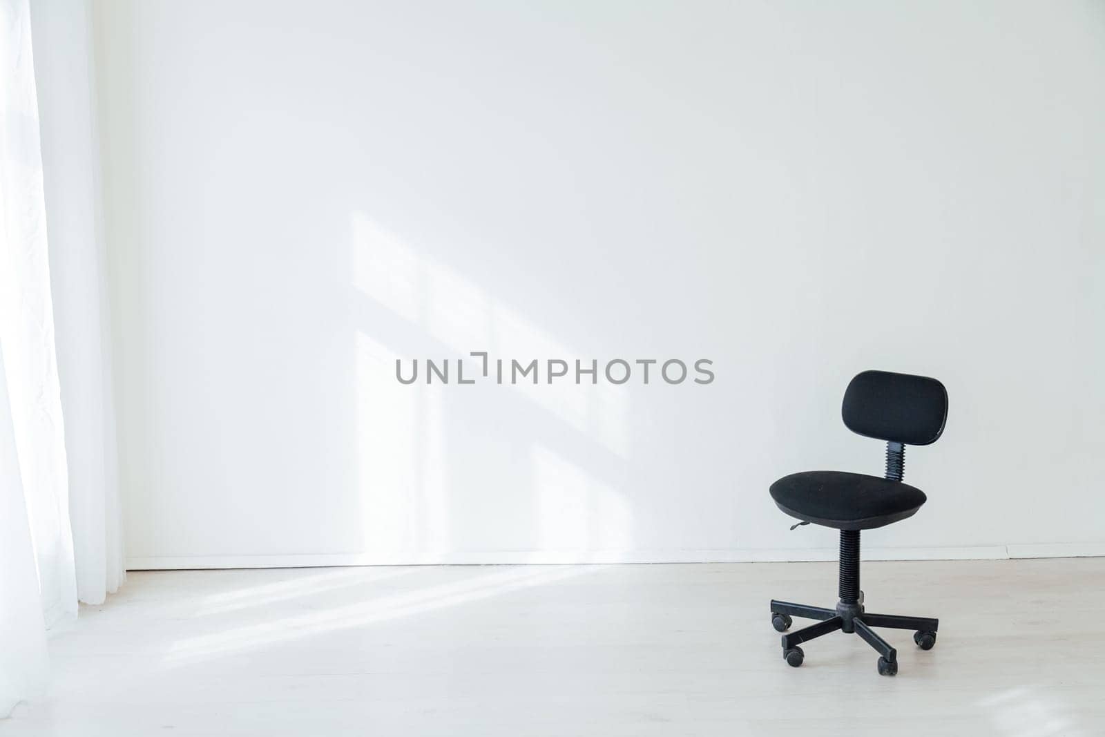 black office chair in an empty white office by Simakov