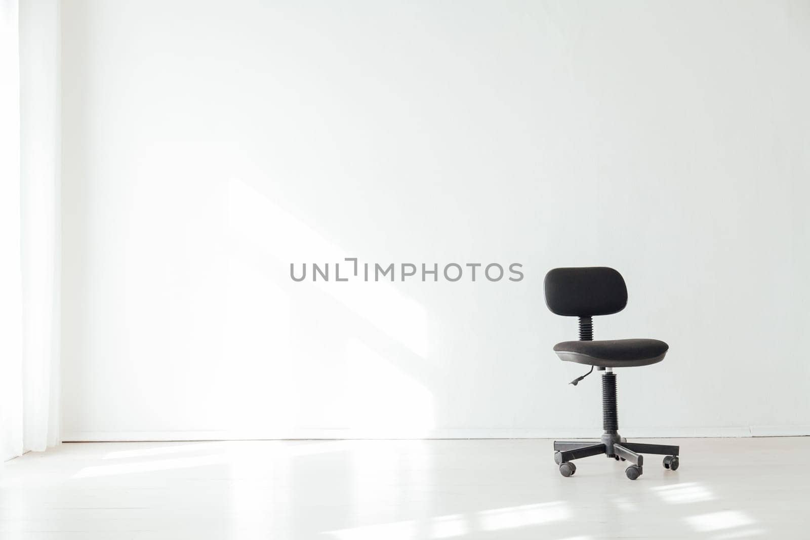 black office chair in an empty white office by Simakov