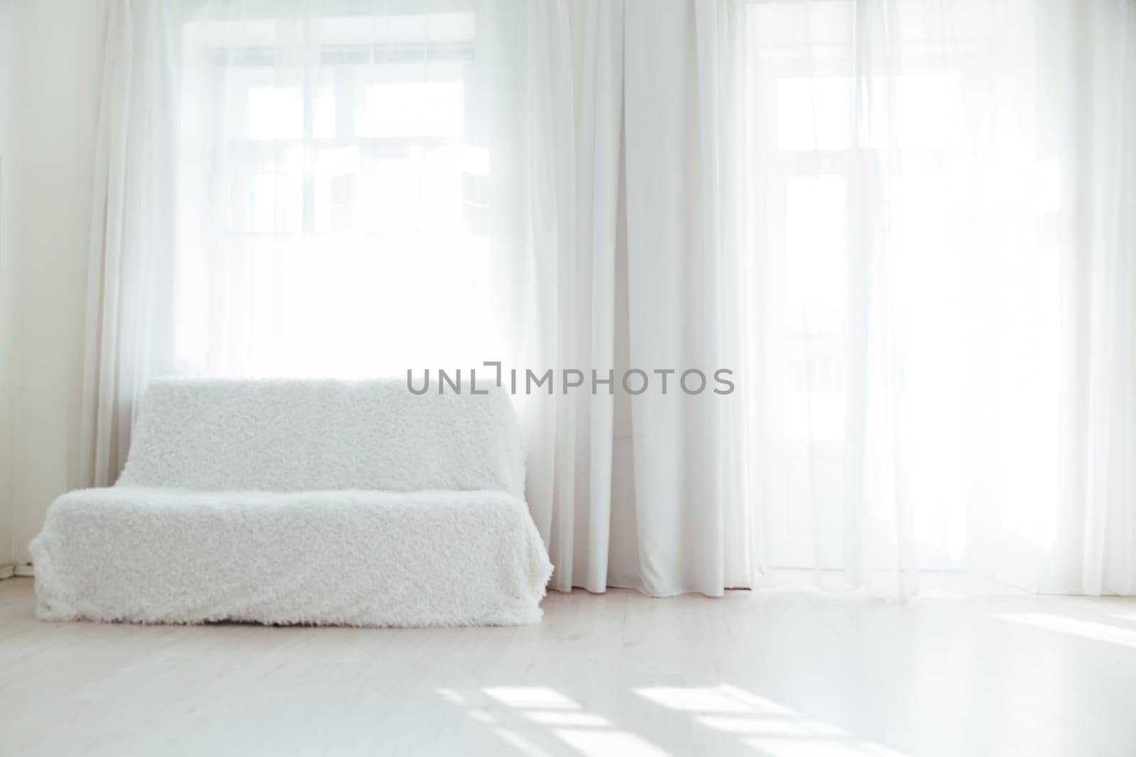 white sofa in the interior of a room with windows