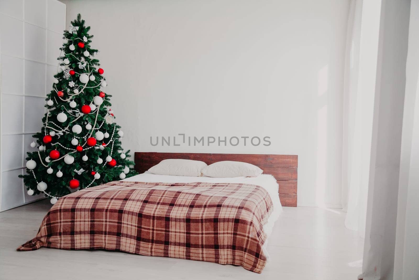Interior bedroom with bed and Christmas tree new year holidays gifts by Simakov