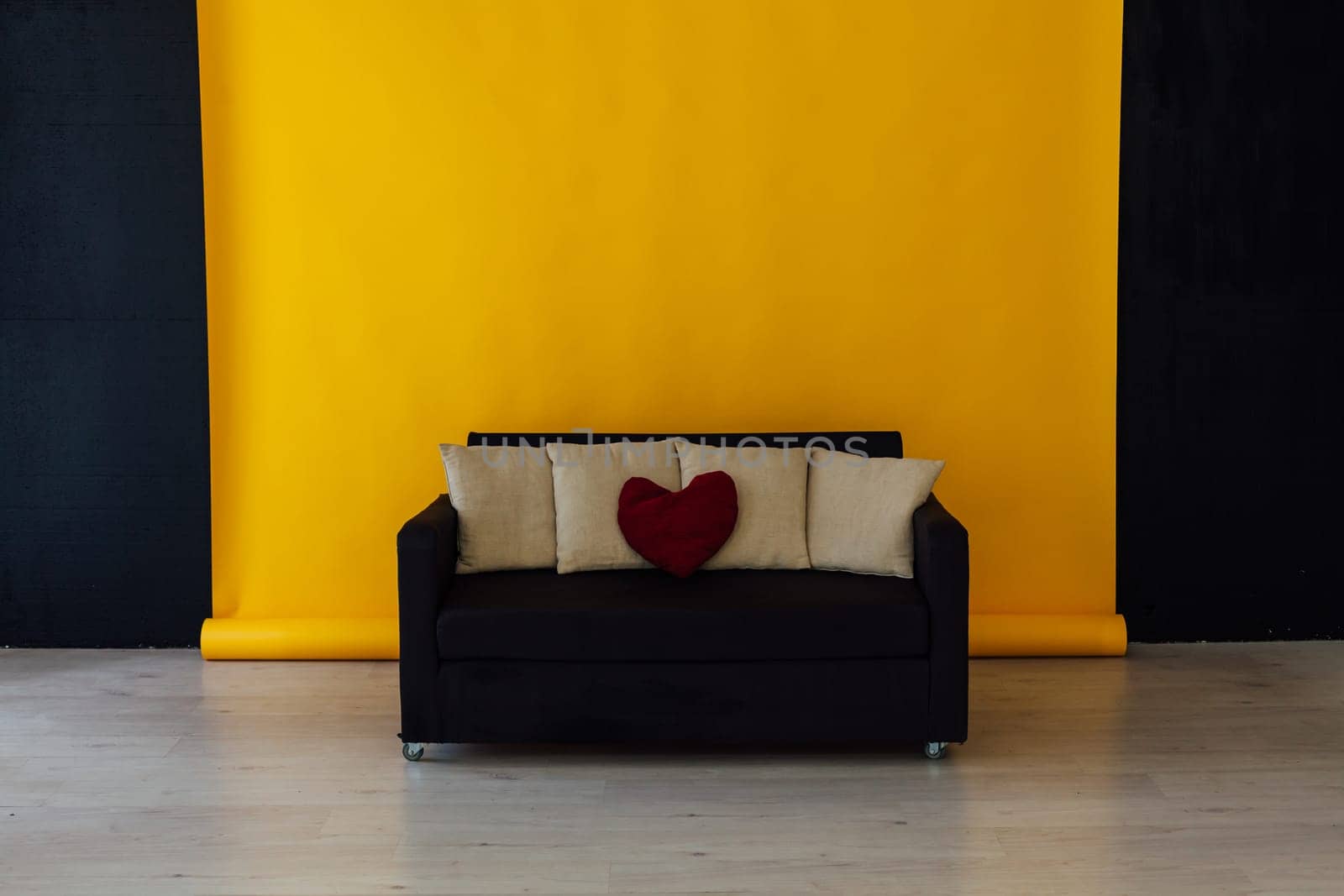 black sofa in the interior of the yellow room