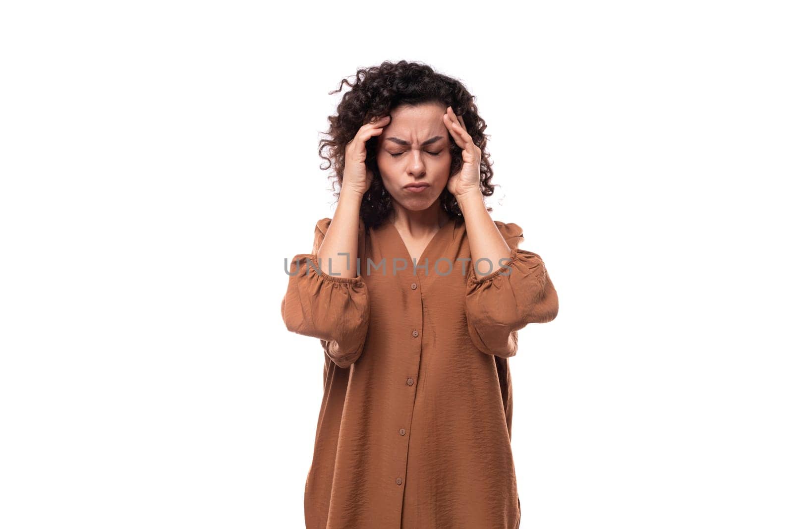 young fashionista curly brunette woman dressed in a brown blouse is worried by TRMK
