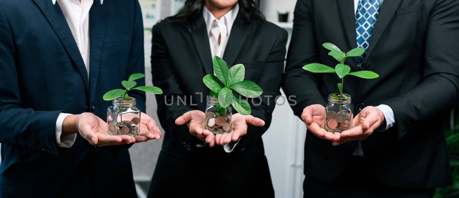 Business people holding money savings jar filled with coins and growing plant for sustainable financial planning for retirement or eco subsidy investment for environment protection. Quaint