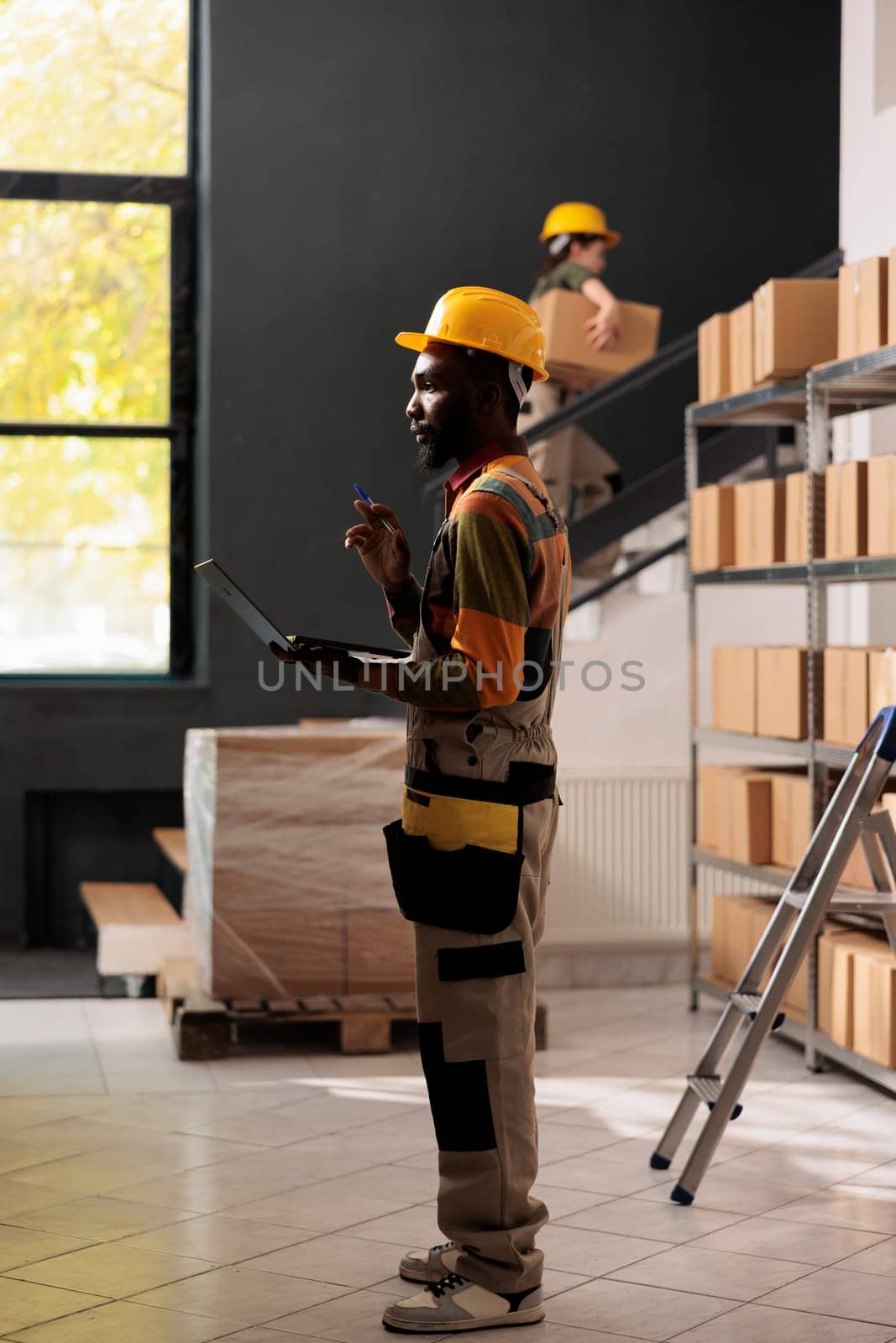 African american employee analyzing inventory checklist by DCStudio