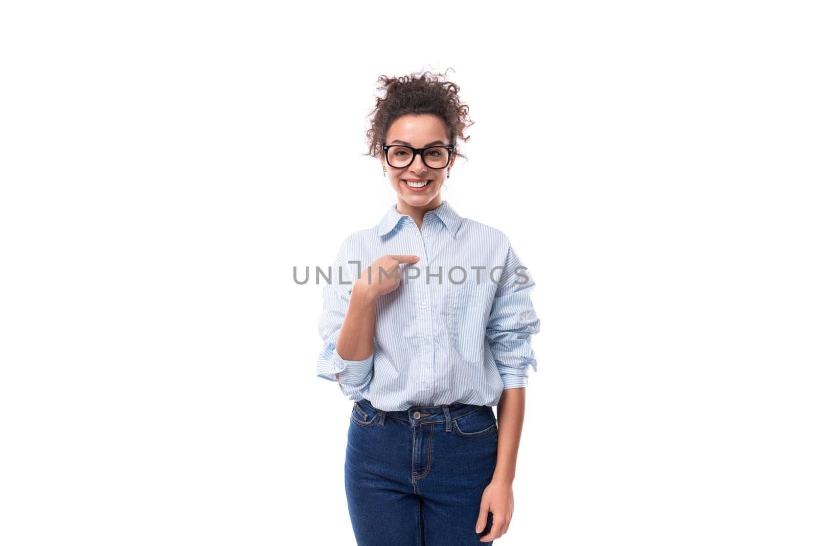 beautiful young stylish caucasian office worker woman with curly hair points her finger at advertising space. advertising concept by TRMK