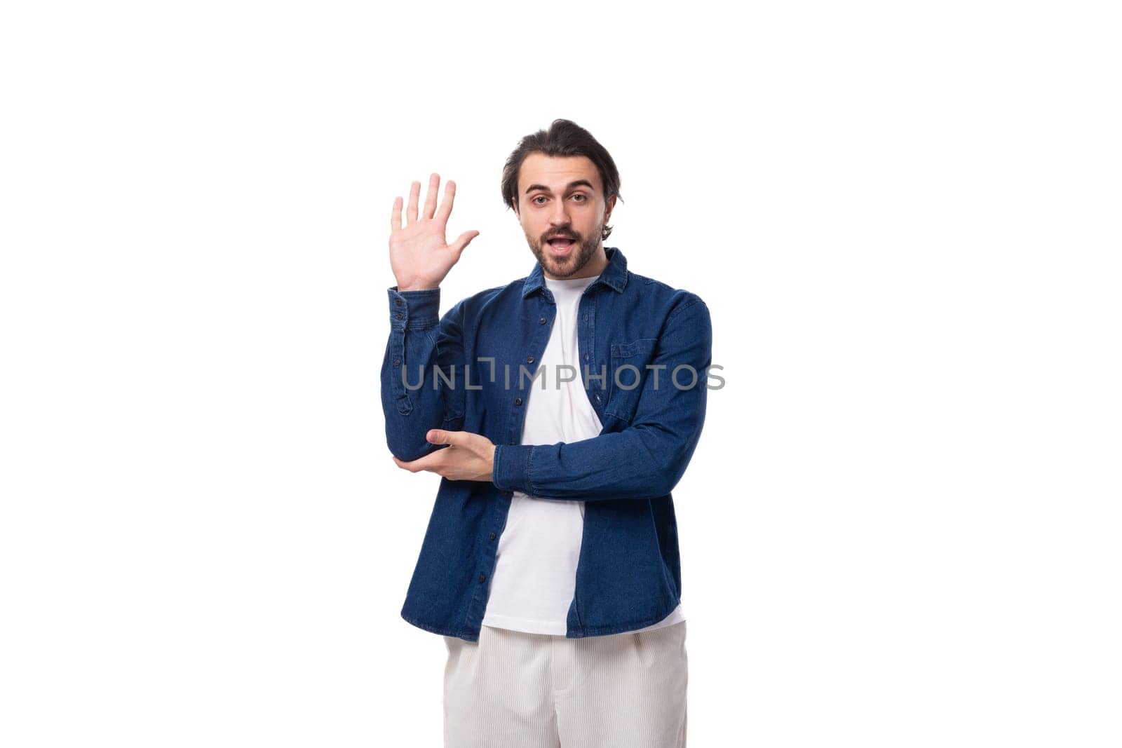 young smart caucasian man with black hair is dressed in a blue shirt and t-shirt.